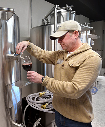 Waters Edge Winery owner Mike Vandy pours a glass of his popular red.