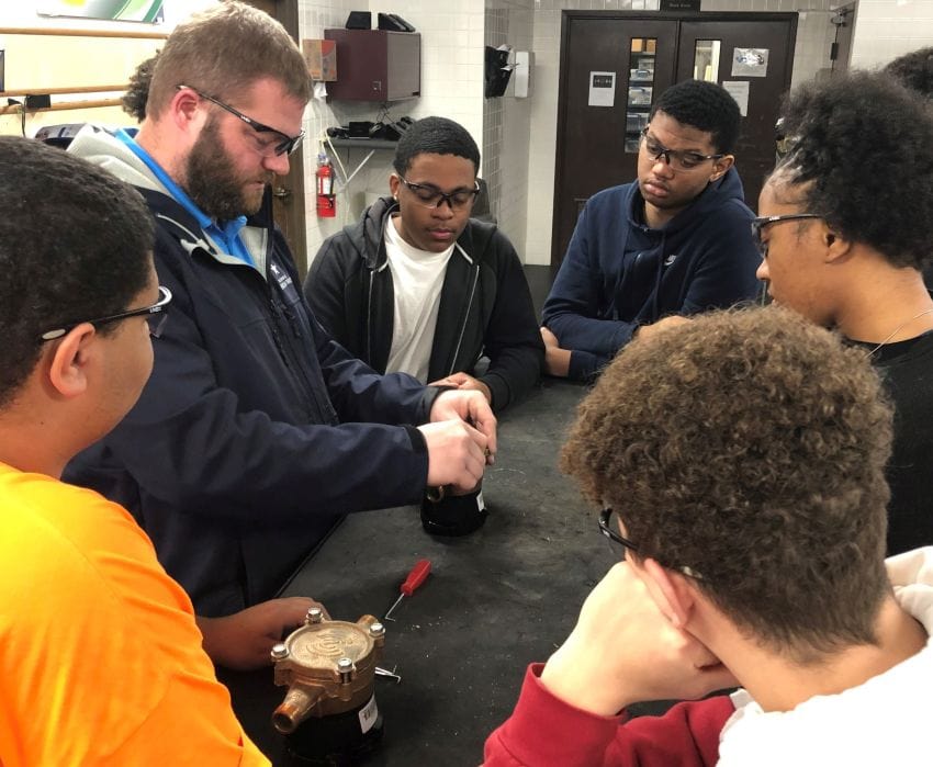 Ryan Krolicki, senior superintendent of field operations, shows students at Woodruff Career & Technical Center how to assemble a meter.