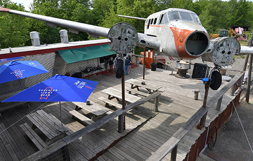 An old air plane fuselage hanging above the outdoor deck