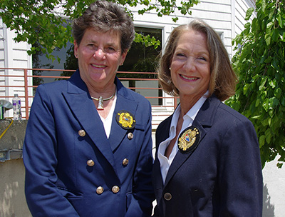Two women in blue suit jackets