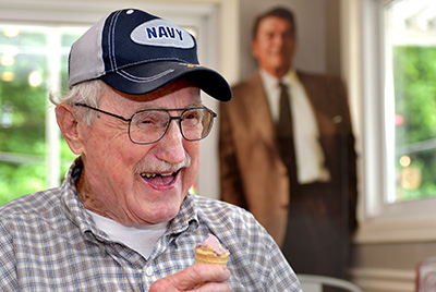 older man eating an ice cream inside the shop.