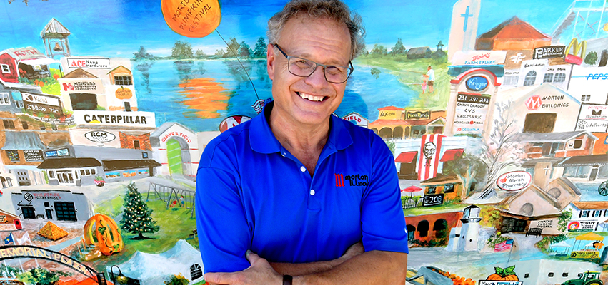 A man standing in front of a mural of Morton, Illinois.
