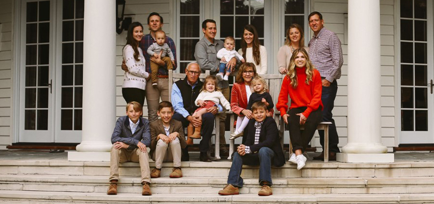 Family sitting for a portrait on a front porch