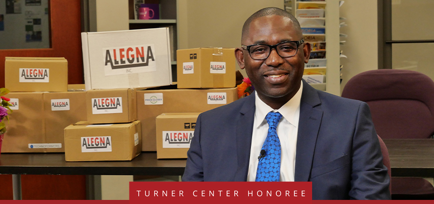 Turner Center Nominee: A man sitting in front of a stack of boxes with with "Alegna" labels on the,