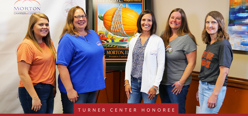 Turner Center Nominee: A group standing in front of Morton Marketing posters