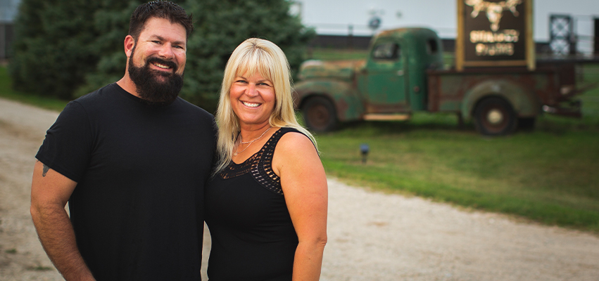 Rob and Emily Sharky standing in front of their farm