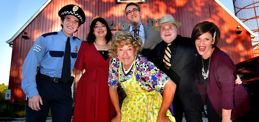 Cast members of a show standing in front of the Barn Theatre