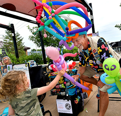 Man creating Balloon art for a young girl