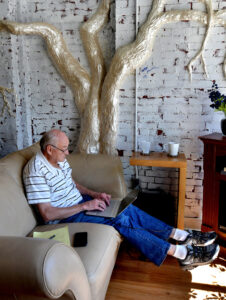 A man sitting in a coffee shop reading a book.