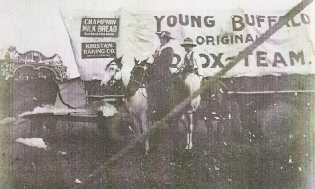 A covered wagon with people on horses