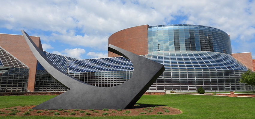 A photo of Sonar Tide Sculpture with the Peoria Civic Center in the background