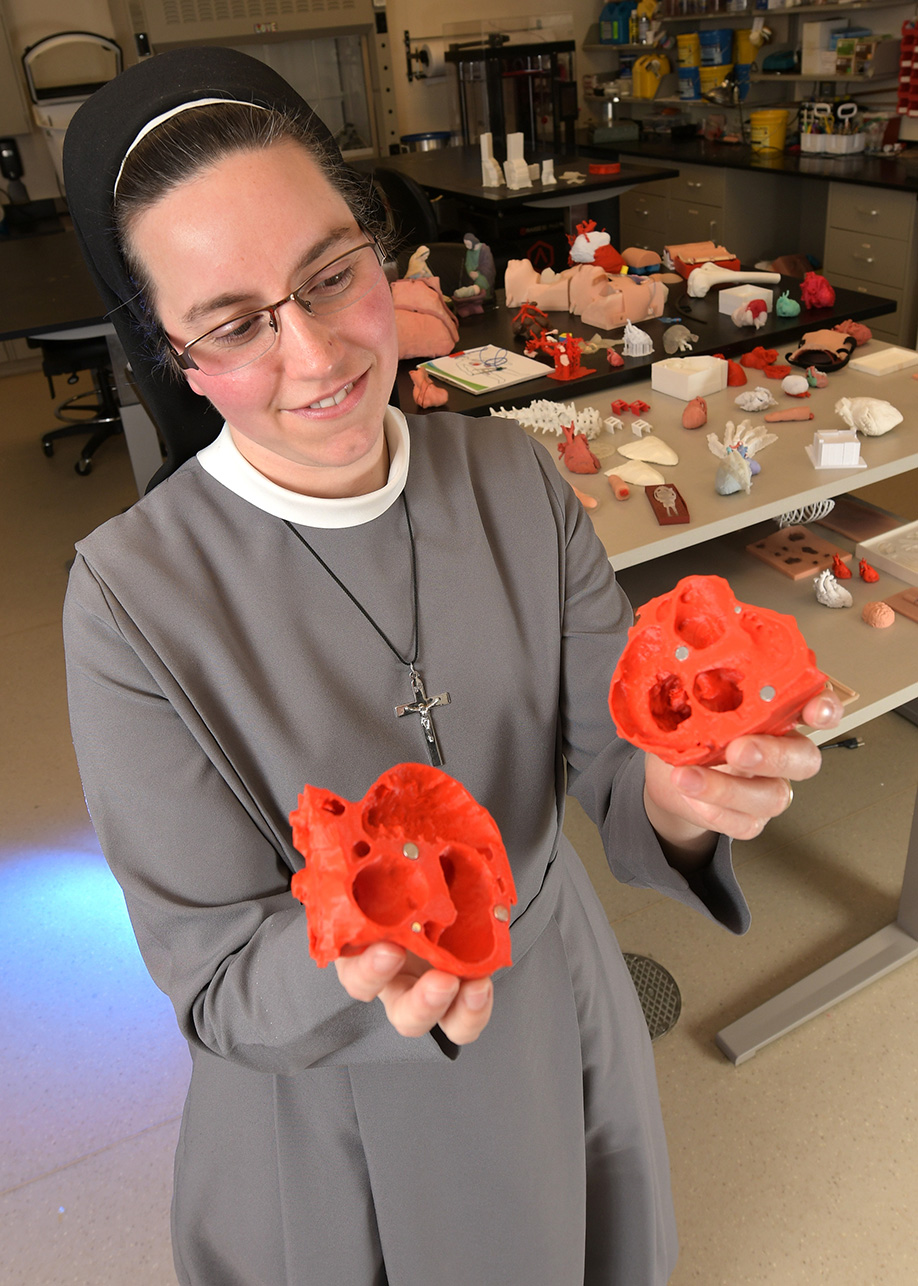 Sister M. Pieta Keller, an innovation engineer, displays a model of a heart made by the 3D printer in her Jump Center lab