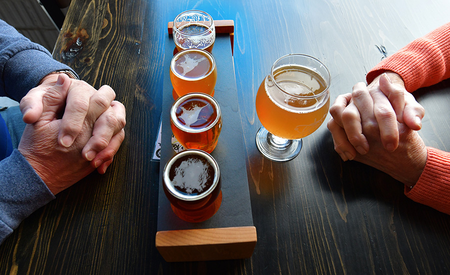 Scott Chockley, left, and Denise Flynn, both of Peoria, partake in a flight and pint of beer at Analytical Brewing