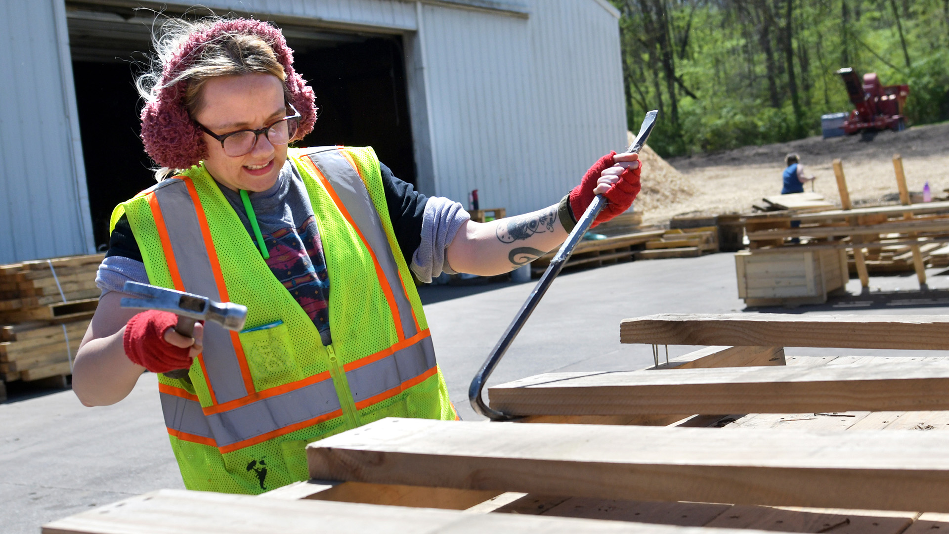 A student tears down wooden crates and pallets at Victory Acres Peoria