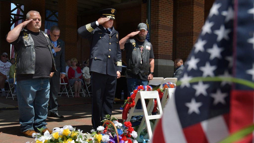 Peoria Police Chief Eric Echevarria, middle, salutes the fallen during the Memorial Day program