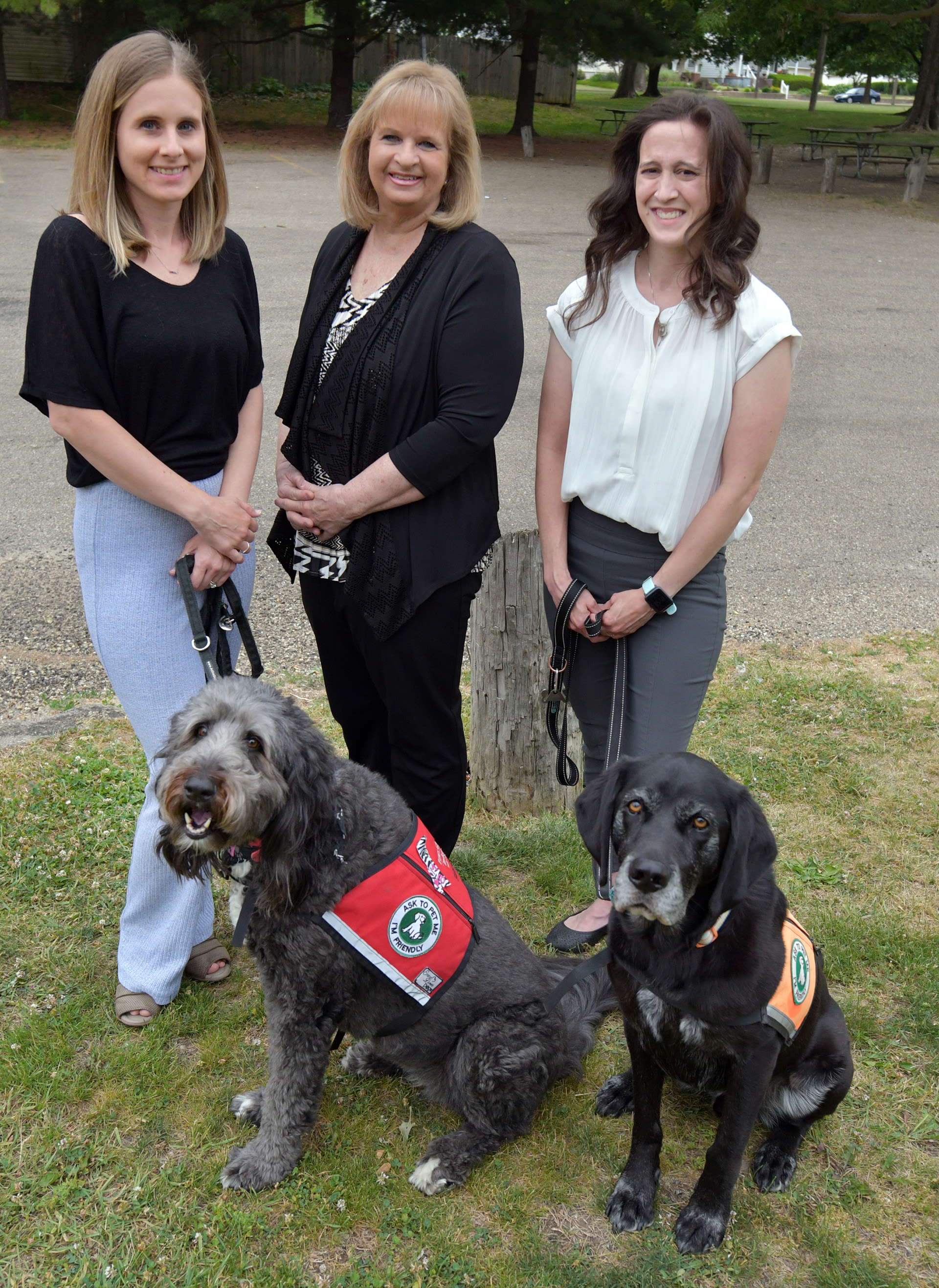 Left to right, Michelle Yuen with facility dog Lucie, Donna Kosner, and Brandy Weyers with Jarvis. These three women are the founders of Paws Giving Independence