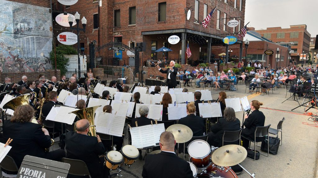 Dr. David Vroman directs the Peoria Municipal Band during a performance on June 14 on Water Street in the Warehouse District. The band performs each Sunday at the Glen Oak Amphitheater and Wednesdays on Water Street through Aug. 13