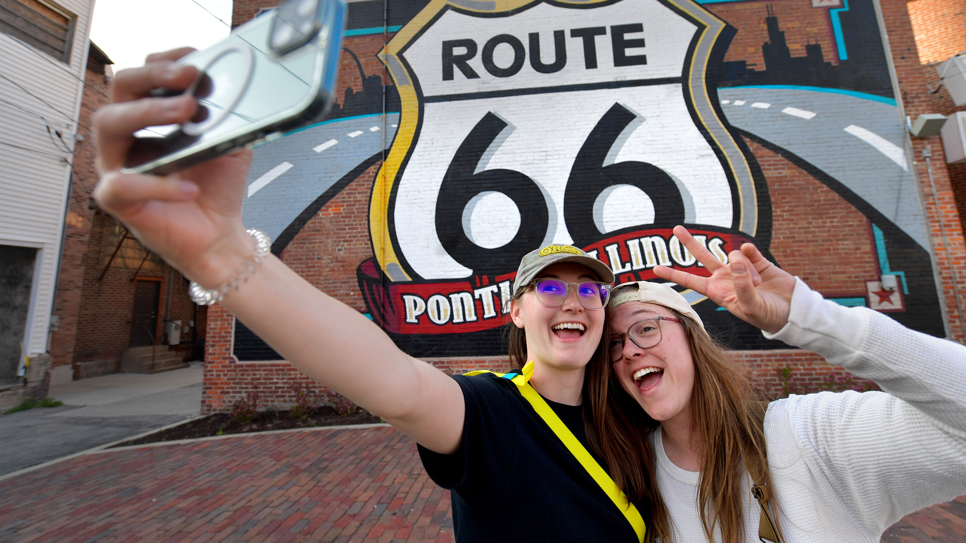 Drew Stanford, left, and Susie Mason get their kicks by taking selfies in front of the mural on the Route 66 Association Hall of Fame and Museum in downtown Pontiac