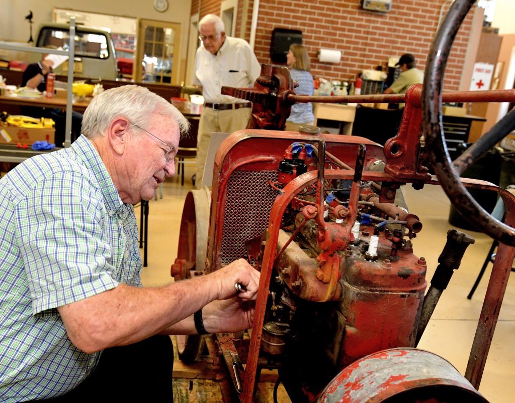 Volunteer Mike Wasson works to restore an Avery tractor