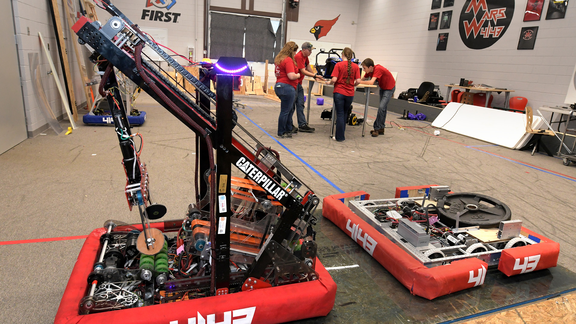 Students Hunter Weyant, Eli Reutter, and Josie Hess work on a Mars Wars car at Metamora High School